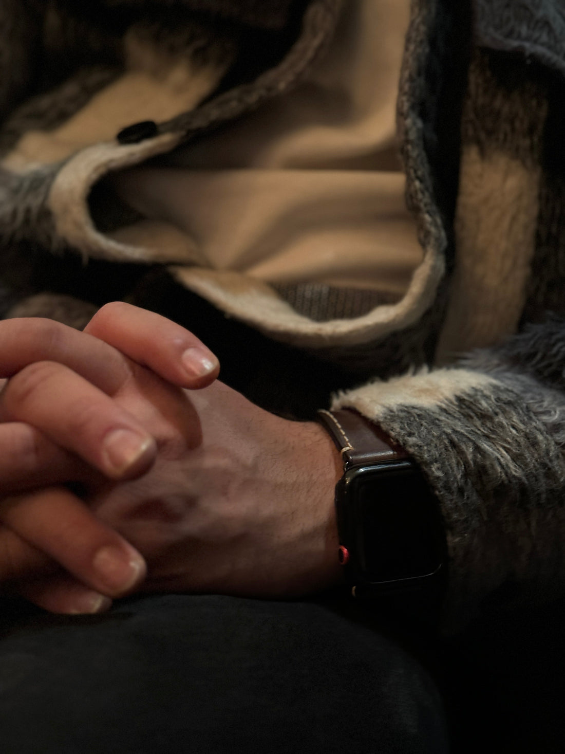 Apple Watch mit braunem Rindslederarmband am Handgelenk, Fokus auf hochwertiges Uhrenarmband