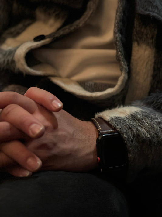 Apple Watch mit braunem Rindslederarmband am Handgelenk, Fokus auf hochwertiges Uhrenarmband