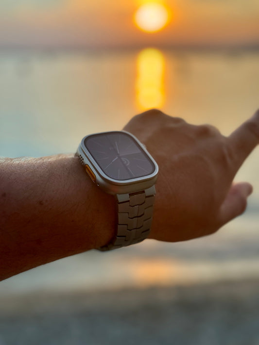 Apple Watch mit Metallarmband am Handgelenk bei Sonnenuntergang am Strand, A-Watch-Armband