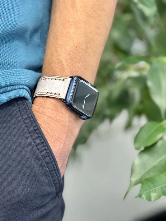 Apple Watch mit beigem Rindslederarmband am Handgelenk, lässig getragen, A-Watch-Armband