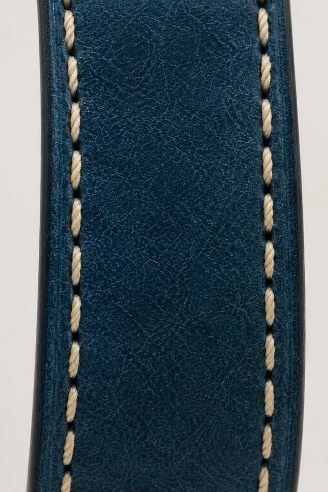 Detailansicht der blauen Lederoberfläche und der hellen Naht